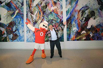 Sebastian the Ibis and UM alum and renowned Miami artist Xavier Cortada celebrate the unveiling of the digital tapestry Cortada created for the Student Activities Center's third floor.