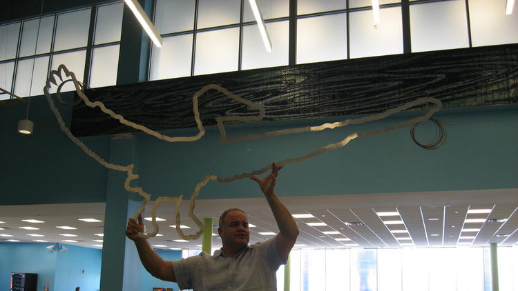 Miami artist Xavier Cortada displays a metallic pelican - the final piece of his new 